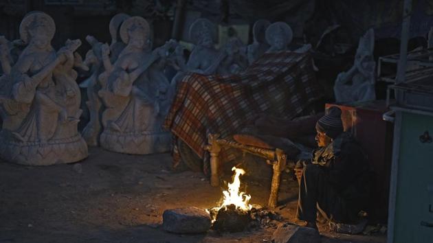 A man guarding idols at an artiste’s place warms himself by fire near the Akshardham Temple. (Ravi Choudhary/HT PHOTO) A man guarding idols at an artiste’s place warms himself by fire near the Akshardham Temple. (Ravi Choudhary/HT PHOTO)