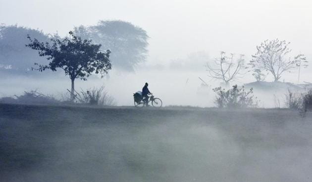 A cyclist makes his way through early morning fog on a cold wintry day on the banks of the Yamuna river in New Delhi. (Ravi Choudhary/HT PHOTO) A cyclist makes his way through early morning fog on a cold wintry day on the banks of the Yamuna river in New Delhi. (Ravi Choudhary/HT PHOTO)
