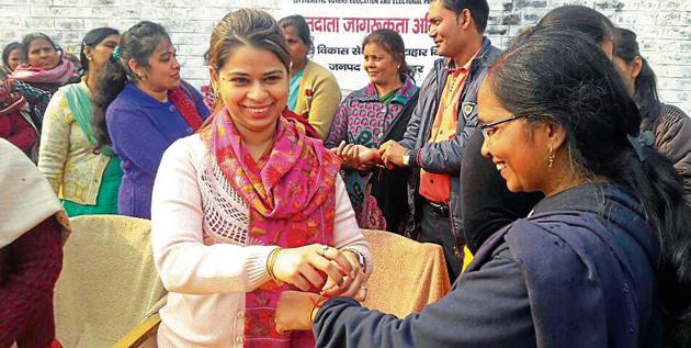 An activist tying a thread on a women’s wrist as part of voter awareness campaign in Bulandshahr. (HT Photo) An activist tying a thread on a women’s wrist as part of voter awareness campaign in Bulandshahr. (HT Photo)