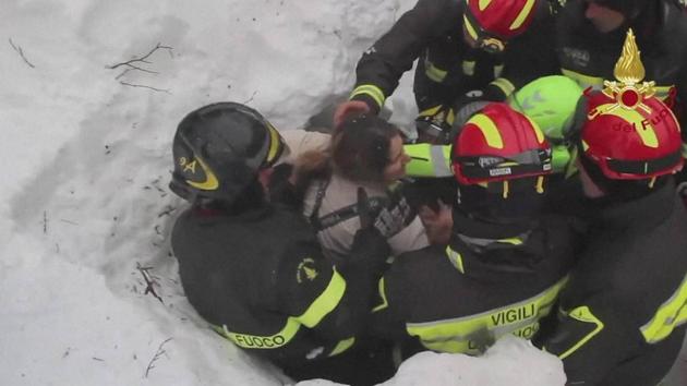 Italian firefighters pull out a woman from the snow and debris of a hotel that was hit by an avalanche on Wednesday, in Rigopiano, central Italy, on January 20, 2017. Eight people were rescued so far from the hotel. (AP) Italian firefighters pull out a woman from the snow and debris of a hotel that was hit by an avalanche on Wednesday, in Rigopiano, central Italy, on January 20, 2017. Eight people were rescued so far from the hotel. (AP)