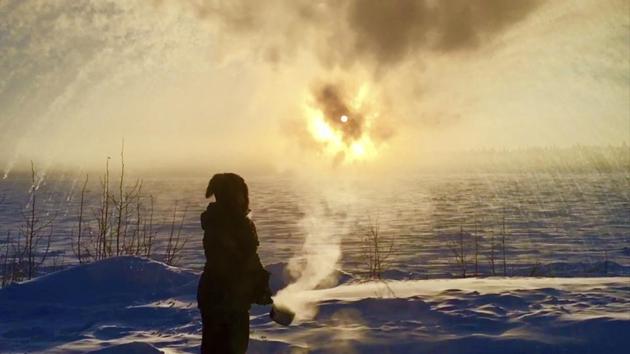 Ice crystals shower down on Courtney Moore Agnes after she flung a pot of boiling water into the air, in Tanana, Alaska. (AP Photo) Ice crystals shower down on Courtney Moore Agnes after she flung a pot of boiling water into the air, in Tanana, Alaska. (AP Photo)