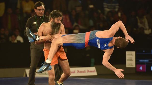 Baba Ramdev and Andrey Stadnik, Olympic Medalist in action during the Pro Wresting league-2 at K D Jadhav Stadium, I G Stadium in New Delhi. (Virendra Singh Gosain/HT PHOTO) Baba Ramdev and Andrey Stadnik, Olympic Medalist in action during the Pro Wresting league-2 at K D Jadhav Stadium, I G Stadium in New Delhi. (Virendra Singh Gosain/HT PHOTO)