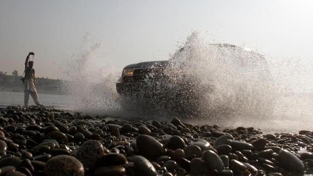 A photographer takes pictures as an SUV takes part in the Indus river water cross race in Swabi, outside Peshawar, Pakistan December 18. (REUTERS) A photographer takes pictures as an SUV takes part in the Indus river water cross race in Swabi, outside Peshawar, Pakistan December 18. (REUTERS)