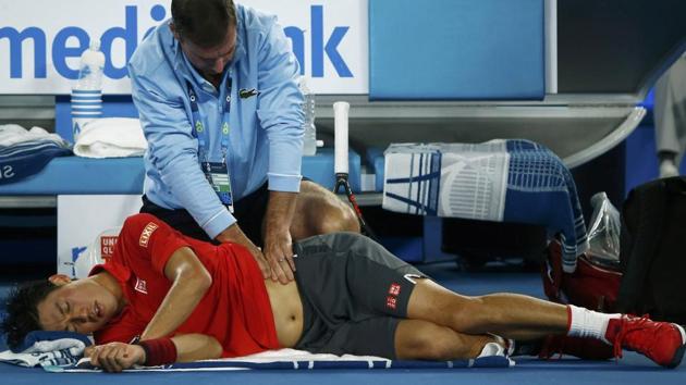 Kei Nishikori received extensive on-court treatment for a back problem during his fourth-round match against Roger Federer. (REUTERS)
