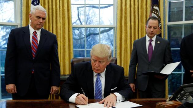 US President Donald Trump signs an executive order on US withdrawal from the Trans Pacific Partnership while flanked by Vice President Mike Pence (L) and White House Chief of Staff Reince Priebus (R) in the Oval Office of the White House in Washington.(Reuters Photo) US President Donald Trump signs an executive order on US withdrawal from the Trans Pacific Partnership while flanked by Vice President Mike Pence (L) and White House Chief of Staff Reince Priebus (R) in the Oval Office of the White House in Washington.(Reuters Photo)