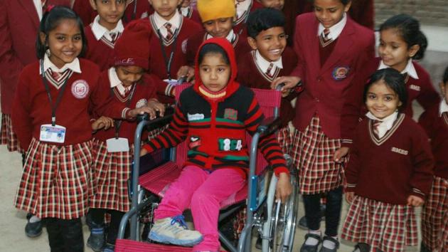 Students of Stepping Stone English Modern School with Usha, the differently abled daughter of a labourer in Sri Ganganagar district, to whom they gifted a wheelchair last week.(HT Photo)