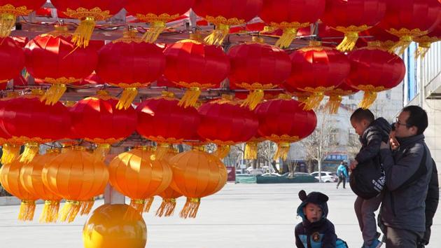 A man lifts a child up to lantern decorations set up ahead of the Chinese New Year in Beijing. Chinese authorities said 18.46 million children were born last year, an increase of 1.31 million from 2015. Nearly half of the children were born to couples who already had a child, they said.(AP)