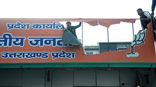 Protestors tear a hoarding at the BJP office in Dehradun on Tuesday. (Vinay Santosh Kumar/HT photo) Protestors tear a hoarding at the BJP office in Dehradun on Tuesday. (Vinay Santosh Kumar/HT photo)