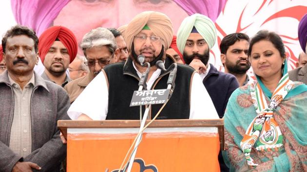 Captain Amarinder Singh flanked by Mangat Rai Bansal (left) and Manju Bansal, who is the party candidate from Mansa, at a rally on Tuesday.(HT Photo)