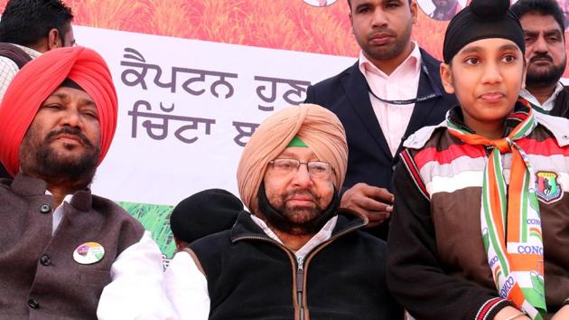 Punjab Congress chief Captain Amarinder Singh with party’s Bathinda Rural candidate Harvinder Singh Laddi during a rally at Kotshamir village on Tuesday.(Sanjeev Kumar/HT Photo)