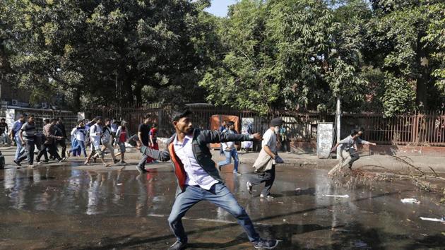 A Bangladeshi protestor throws a rock towards policemen during a protest demanding the scrapping of the proposed Rampal power plant, in Dhaka.(AP Photo)