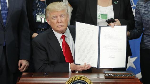 President Donald Trump holds up an executive order for border security and immigration enforcement improvements after signing the order during a visit to the Homeland Security Department headquarters in Washington.(AP Photo) President Donald Trump holds up an executive order for border security and immigration enforcement improvements after signing the order during a visit to the Homeland Security Department headquarters in Washington.(AP Photo)