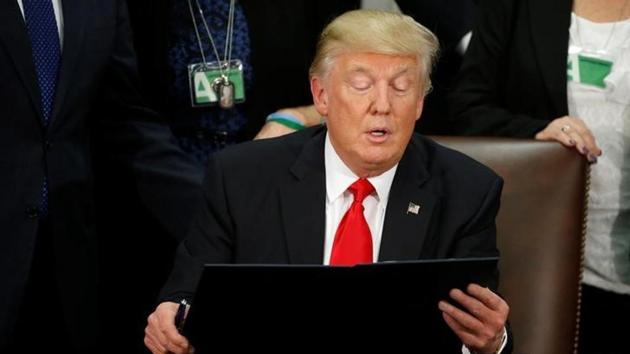US President Donald Trump reads an executive order before signing it at Homeland Security headquarters in Washington, US.(Reuters Photo) US President Donald Trump reads an executive order before signing it at Homeland Security headquarters in Washington, US.(Reuters Photo)