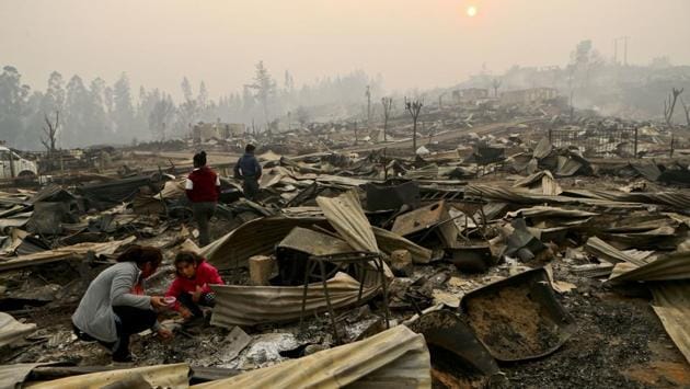 The Vega Salinas family searches what's left of their fire-destroyed home in Santa Olga, Chile. (Esteban Felix/AP) The Vega Salinas family searches what's left of their fire-destroyed home in Santa Olga, Chile. (Esteban Felix/AP)