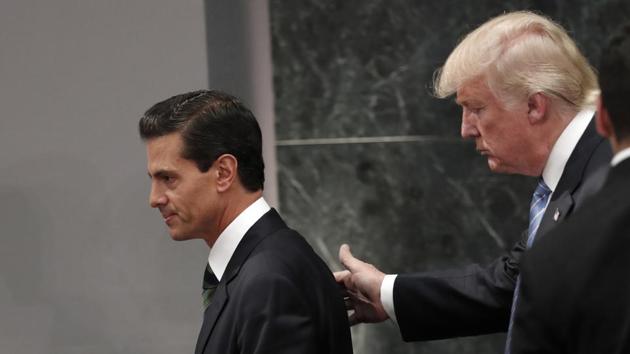 Mexican President Enrique Pena Nieto (left) with then US presidental nominee Donald Trump in August 2016. Nieto cancelled his upcoming trip to Washington as the White House proposed a 20%import tax on Mexico amid the spat over the border wall between the two countries. (AP File Photo) Mexican President Enrique Pena Nieto (left) with then US presidental nominee Donald Trump in August 2016. Nieto cancelled his upcoming trip to Washington as the White House proposed a 20%import tax on Mexico amid the spat over the border wall between the two countries. (AP File Photo)
