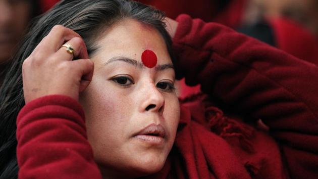 A Nepalese woman adjusts her hair as she waits to offer prayers during Madhav Narayan festival in Kathmandu, Nepal. (Niranjan Shrestha / AP)