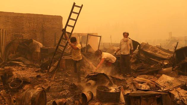 People look for salvageable items among the debris of a burnt house as the worst wildfires hit Chile. (Pablo Sanhueza/REUTERS) People look for salvageable items among the debris of a burnt house as the worst wildfires hit Chile. (Pablo Sanhueza/REUTERS)