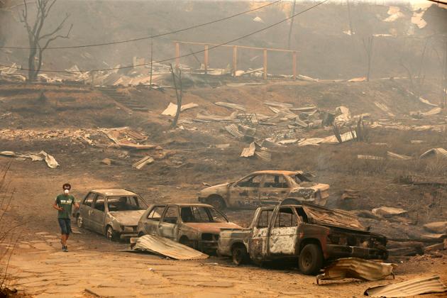 A man walks past burnt cars after the wildfire. (Pablo Sanhueza/REUTERS) A man walks past burnt cars after the wildfire. (Pablo Sanhueza/REUTERS)