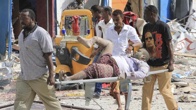 Somali men carry a civilian who was wounded in a suicide car bomb attack on a hotel in Mogadishu, Somalia. (AP Photo) Somali men carry a civilian who was wounded in a suicide car bomb attack on a hotel in Mogadishu, Somalia. (AP Photo)