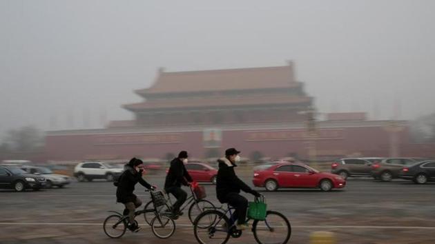 People wearing masks cycle past Tiananmen Gate during the smog after a red alert was issued for heavy air pollution in Beijing, China, December 20, 2016. (Reuters File Photo) People wearing masks cycle past Tiananmen Gate during the smog after a red alert was issued for heavy air pollution in Beijing, China, December 20, 2016. (Reuters File Photo)