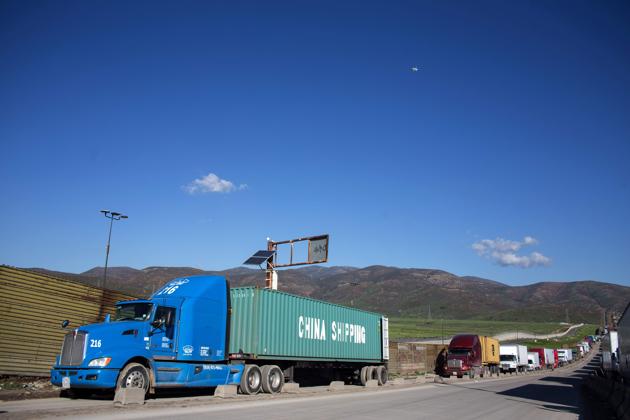 Trucks line up to cross to the United States near the Otay Commercial port of entry on the Mexican side of the US-Mexico border. (AFP Phooto)
