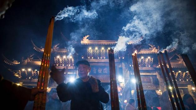 A man prays with incense sticks at the Longhua temple in Shanghai. (Johannes Eisele/AFP)