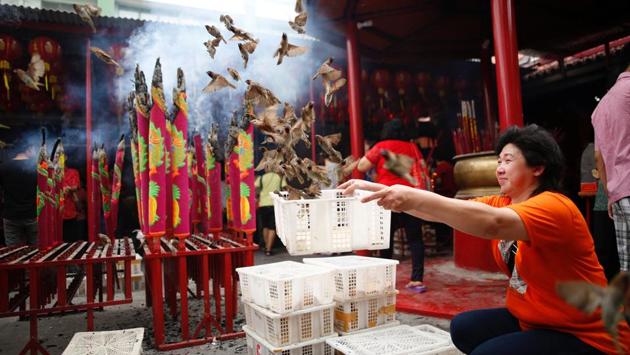 A woman releases birds for good luck during Lunar New Year celebrations at Dharma Bhakti temple in Jakarta, Indonesia. (Darren Whiteside/REUTERS)