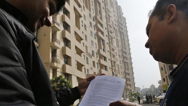 Tenants at Fresco, Nirvana Country, read the notice issued to them on the new charges. (Sanchit Khanna/HT Photo) Tenants at Fresco, Nirvana Country, read the notice issued to them on the new charges. (Sanchit Khanna/HT Photo)