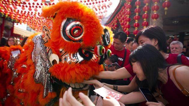 Temple visitors give red packets to the lion dance troupe during the lion dance performance on the first day of Chinese Lunar New Year at a temple in Kuala Lumpur, Malaysia. (Lim Huey Teng/AP)