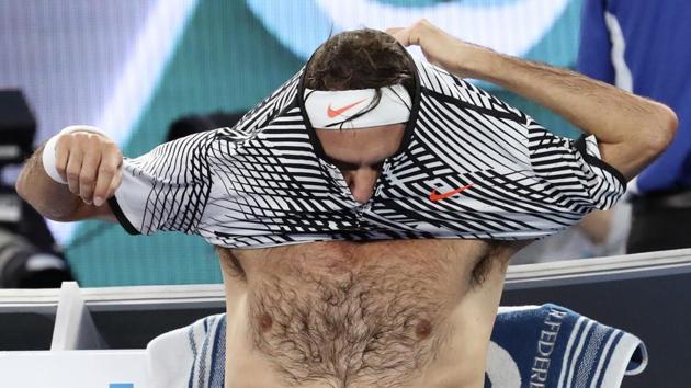 Roger Federer changes shirt during a break in his final against Rafael Nadal on Sunday. (AP)