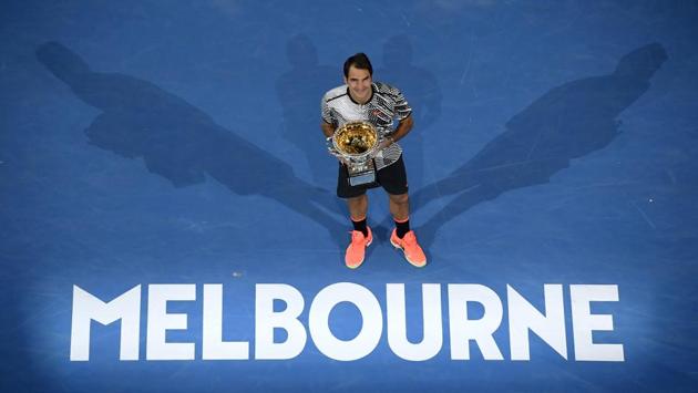 Roger Federer poses with the trophy after it was all over, in Melbourne on Sunday. (AP)