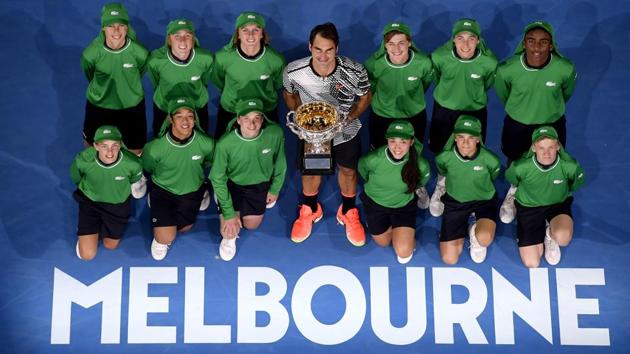 Roger Federer poses with ball kids after winning his 18th Grand Slam, in Melbourne on Sunday. (AP)