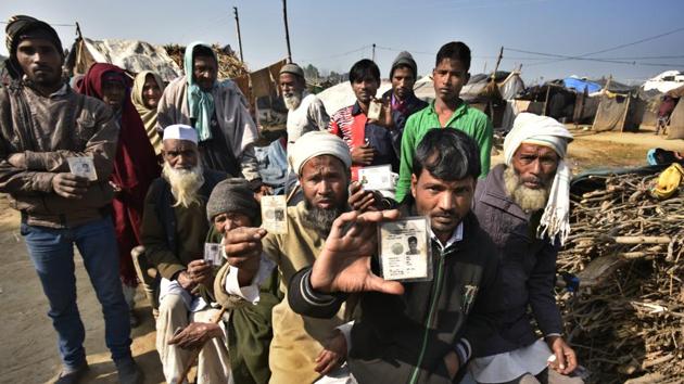 Displaced victims of the Muzaffarnagar riots show their voter ID cards outside their resettlement colony in Kairana, UP.(Raj K Raj/HT Photo)