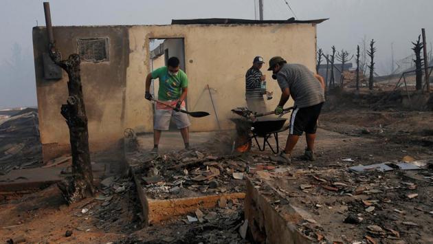 People clean up the remains of a burnt house after a wildfire at the country's central-south regions, in Santa Olga, Chile January 28, 2017. (Carlos Vera / REUTERS) People clean up the remains of a burnt house after a wildfire at the country's central-south regions, in Santa Olga, Chile January 28, 2017. (Carlos Vera / REUTERS)