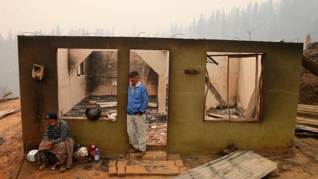 People stay at the remains of a burnt house after a wildfire in the country's central-south regions, in Santa Olga, Chile, January 26, 2017. (Rodrigo Garrido / REUTERS) People stay at the remains of a burnt house after a wildfire in the country's central-south regions, in Santa Olga, Chile, January 26, 2017. (Rodrigo Garrido / REUTERS)