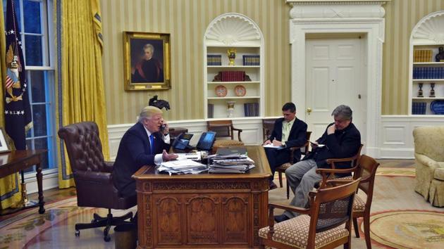 US President Donald Trump speaks on the phone from the Oval Office of the White House, alongside chief strategist Steve Bannon (R) and national security advisor Michael Flynn, on Saturday. (AFP) US President Donald Trump speaks on the phone from the Oval Office of the White House, alongside chief strategist Steve Bannon (R) and national security advisor Michael Flynn, on Saturday. (AFP)