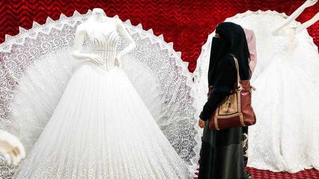 Two Yemeni women, one clad in a burqa, browse through wedding dresses in a shop in the capital Sanaa on January 28, 2017. Despite the conflict in Yemen that led to the deterioration of the economic situation in the country, which was already struggling financially, people continue to spend on weddings and other celebrations. (Mohammed HUWAIS / AFP) Two Yemeni women, one clad in a burqa, browse through wedding dresses in a shop in the capital Sanaa on January 28, 2017. Despite the conflict in Yemen that led to the deterioration of the economic situation in the country, which was already struggling financially, people continue to spend on weddings and other celebrations. (Mohammed HUWAIS / AFP)