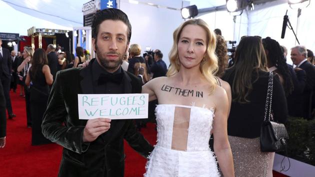 Simon Helberg and Jocelyn Towne display protest signs against the US policy of temporarily barring refugees and citizens of seven predominantly Muslim countries, at the 23rd annual Screen Actors Guild Awards at the Shrine Auditorium & Expo Hall, in Los Angeles. (Matt Sayles/Invision/AP) Simon Helberg and Jocelyn Towne display protest signs against the US policy of temporarily barring refugees and citizens of seven predominantly Muslim countries, at the 23rd annual Screen Actors Guild Awards at the Shrine Auditorium & Expo Hall, in Los Angeles. (Matt Sayles/Invision/AP)