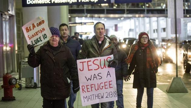 People arrive at the baggage claim area during a protest against President Donald Trump's executive order banning travel to the United States by citizens of several countries Sunday, Jan. 29, 2017, at Detroit Metropolitan Airport. (Jeffrey M. Smith/AP) People arrive at the baggage claim area during a protest against President Donald Trump's executive order banning travel to the United States by citizens of several countries Sunday, Jan. 29, 2017, at Detroit Metropolitan Airport. (Jeffrey M. Smith/AP)