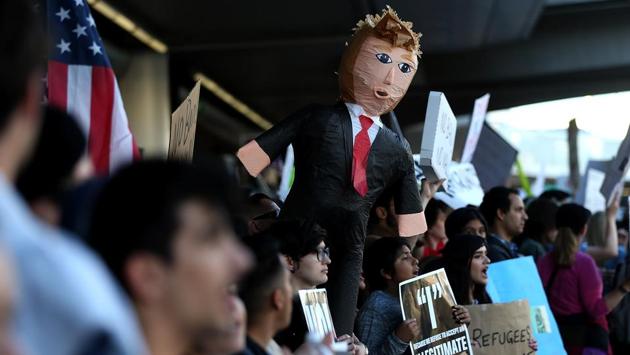 Protesters hold signs during a demonstration against the immigration ban that was imposed by US President Donald Trump at Los Angeles International Airport. (Justin Sullivan/AFP) Protesters hold signs during a demonstration against the immigration ban that was imposed by US President Donald Trump at Los Angeles International Airport. (Justin Sullivan/AFP)