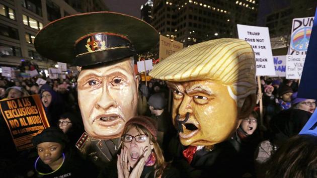 A woman shouts out as she stands in front of effigies portraying Russia's President Vladimir Putin and US President Donald Trump at a rally in Seattle to oppose Trump's executive order banning travel to the US by citizens of several countries .(AP)