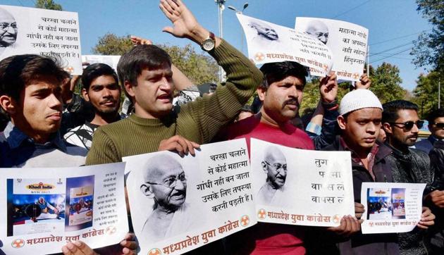 Youth Congress activists at a protest against the removing of Mahatma Gandhi's photos from the Khadi Village Industries Commission calendar. “As far as I understand, there is no need to argue over the merits and demerits of this calendar and create an unnecessary controversy around it,” says the Mahatma’s granddaughter Tara Gandhi Bhattacharjee.(PTI)