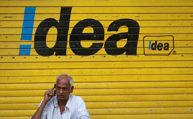 A man speaks on his mobile phone as he sits in front of a shop displaying the Idea Cellular Ltd's logo on its shutter in Mumbai (REUTERS) A man speaks on his mobile phone as he sits in front of a shop displaying the Idea Cellular Ltd's logo on its shutter in Mumbai (REUTERS)