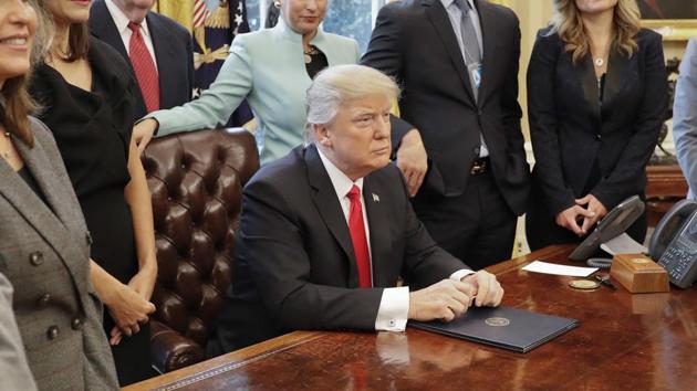 President Donald Trump surrounded by small business leaders poses signing an executive order in the Oval Office of the White House in Washington on Monday. (AP) President Donald Trump surrounded by small business leaders poses signing an executive order in the Oval Office of the White House in Washington on Monday. (AP)