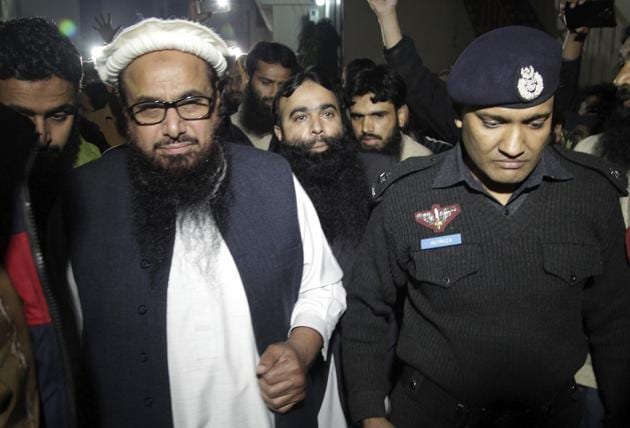 A Pakistani police officer escorts Hafiz Saeed,chief of Pakistan's religious group Jamaat-ud-Dawa outside party's headquarters in Lahore, Pakistan, Monday, Jan. 30.(AP) A Pakistani police officer escorts Hafiz Saeed,chief of Pakistan's religious group Jamaat-ud-Dawa outside party's headquarters in Lahore, Pakistan, Monday, Jan. 30.(AP)