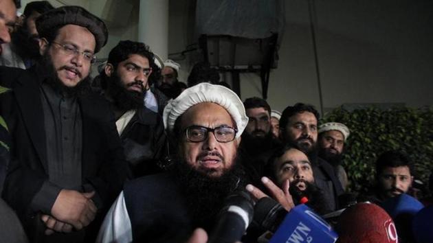 Hafiz Muhammad Saeed, chief of the banned Islamic charity Jamat-ud-Dawa, speaks with media as he is escorted to his home before being put under house arrest in Lahore, Pakistan. (Reuters Photo) Hafiz Muhammad Saeed, chief of the banned Islamic charity Jamat-ud-Dawa, speaks with media as he is escorted to his home before being put under house arrest in Lahore, Pakistan. (Reuters Photo)
