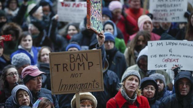 Demonstrators hold signs as they gather in solidarity against President Donald Trump's executive order temporarily banning immigrants from seven Muslim-majority countries from entering the US. (AP Photo) Demonstrators hold signs as they gather in solidarity against President Donald Trump's executive order temporarily banning immigrants from seven Muslim-majority countries from entering the US. (AP Photo)