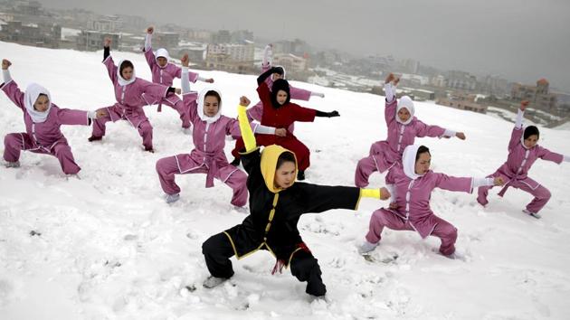 Shaolin martial arts students follow their trainer, Sima Azimi, 20, in black, during a training session on a hilltop in Kabul, Afghanistan.(AP Photo)
