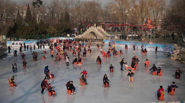 People glide on a frozen lake in a park during the Spring Festival holidays in Beijing. During the week-long holiday, people visit various temple fairs and carnivals around the Chinese capital. (Nicolas ASFOURI / AFP)