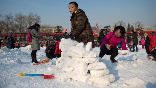 A boy constructs an igloo with snow at an amusement park during the Spring Festival holidays in Beijing. For the Chinese, the Spring Festival is like Christmas in the West, with a spirit of festivity pervading the air. (Nicolas ASFOURI / AFP)
